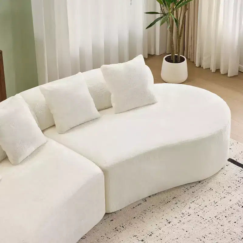 Divano curvo in flanella, moderno e semplice. Creativo divano multi-posto per il soggiorno, con una combinazione di cuscini.